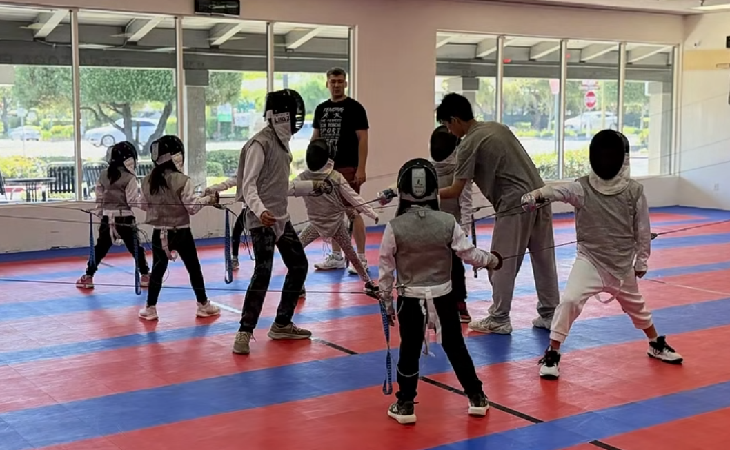 Lucas coaching young fencers